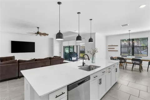 a kitchen with a table chairs and white cabinets