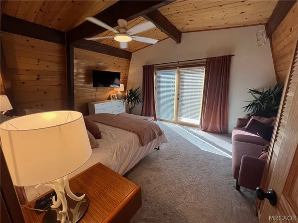 a spacious bedroom with a bed and wooden floor