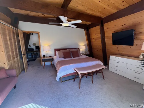 a bedroom with a bed a dresser and a television