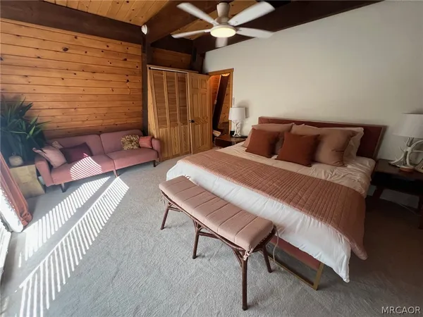 a bedroom with a bed a chair and the dresser