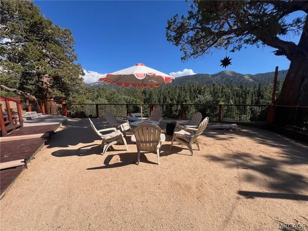 a view of a swimming pool with a bench and trees in the background