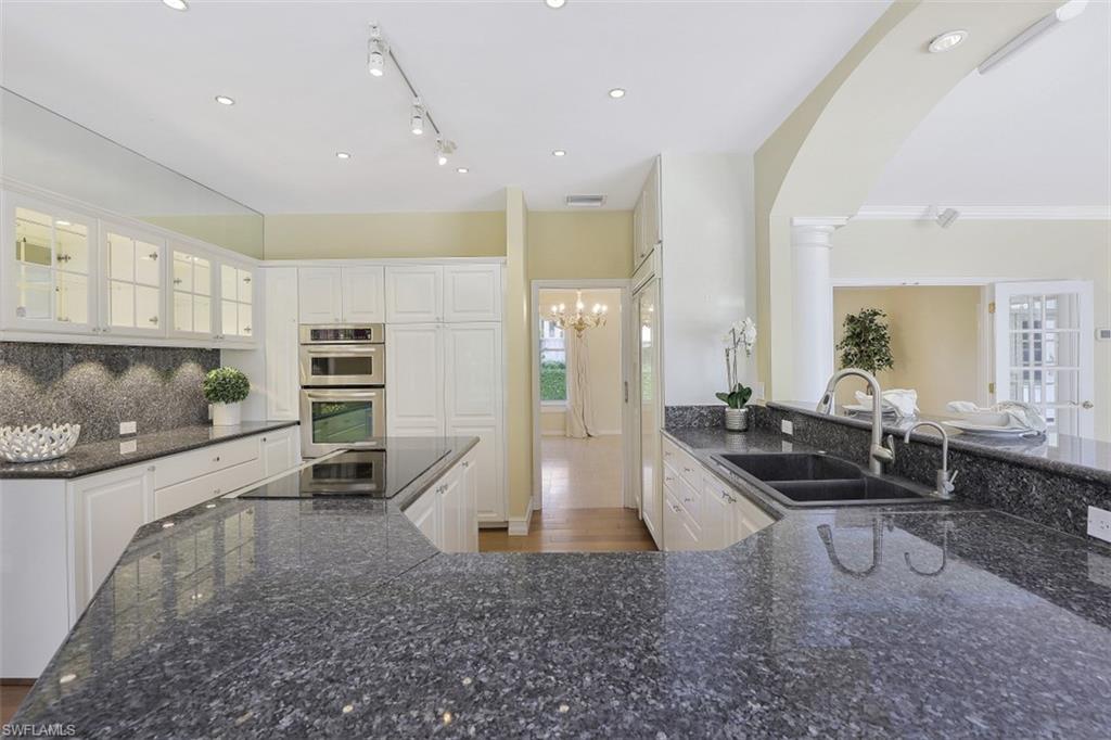 3277 Gordon Drive Naples, FL 34102 - Photo 16 of 33 a large kitchen with stainless steel appliances a stove a sink a refrigerator and a granite counter tops with white cabinets