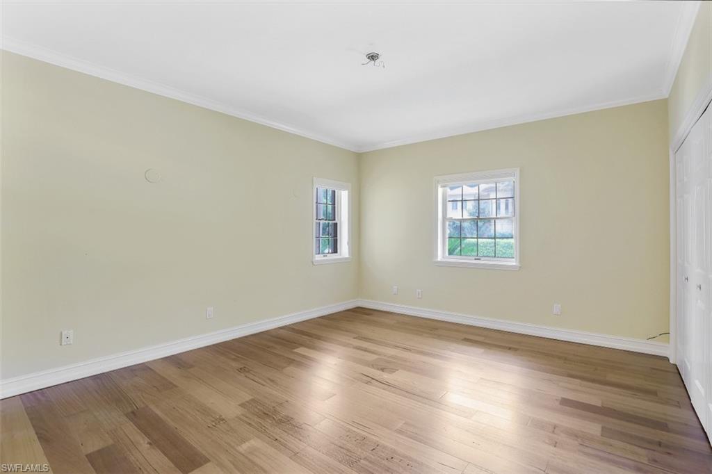 3277 Gordon Drive Naples, FL 34102 - Photo 21 of 33 an empty room with wooden floor and windows