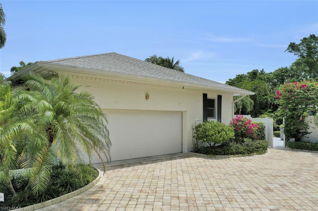 3277 Gordon Drive Naples, FL 34102 - Photo 29 of 33 a front view of a house with a yard and garage
