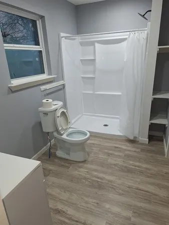 a bathroom with a toilet and a shower