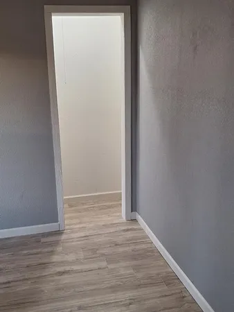 a view of an empty room with wooden floor