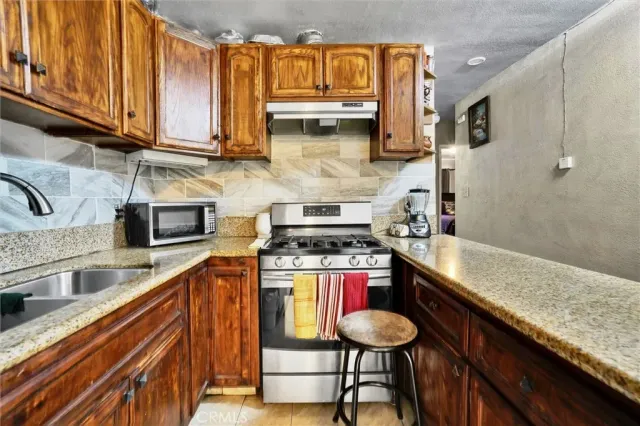 a kitchen with stainless steel appliances granite countertop a sink stove and cabinets
