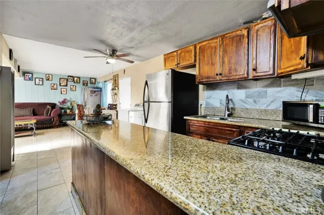 a kitchen with stainless steel appliances granite countertop a sink stove and refrigerator