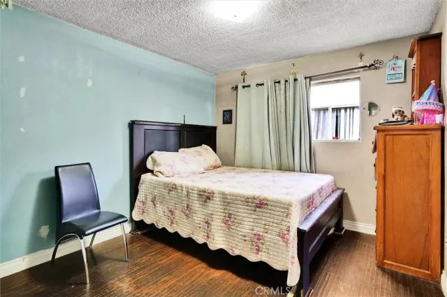 a bed sitting in a bedroom next to a window with chair and table