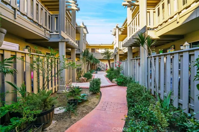 a view of a pathway of a house with a yard and potted plants