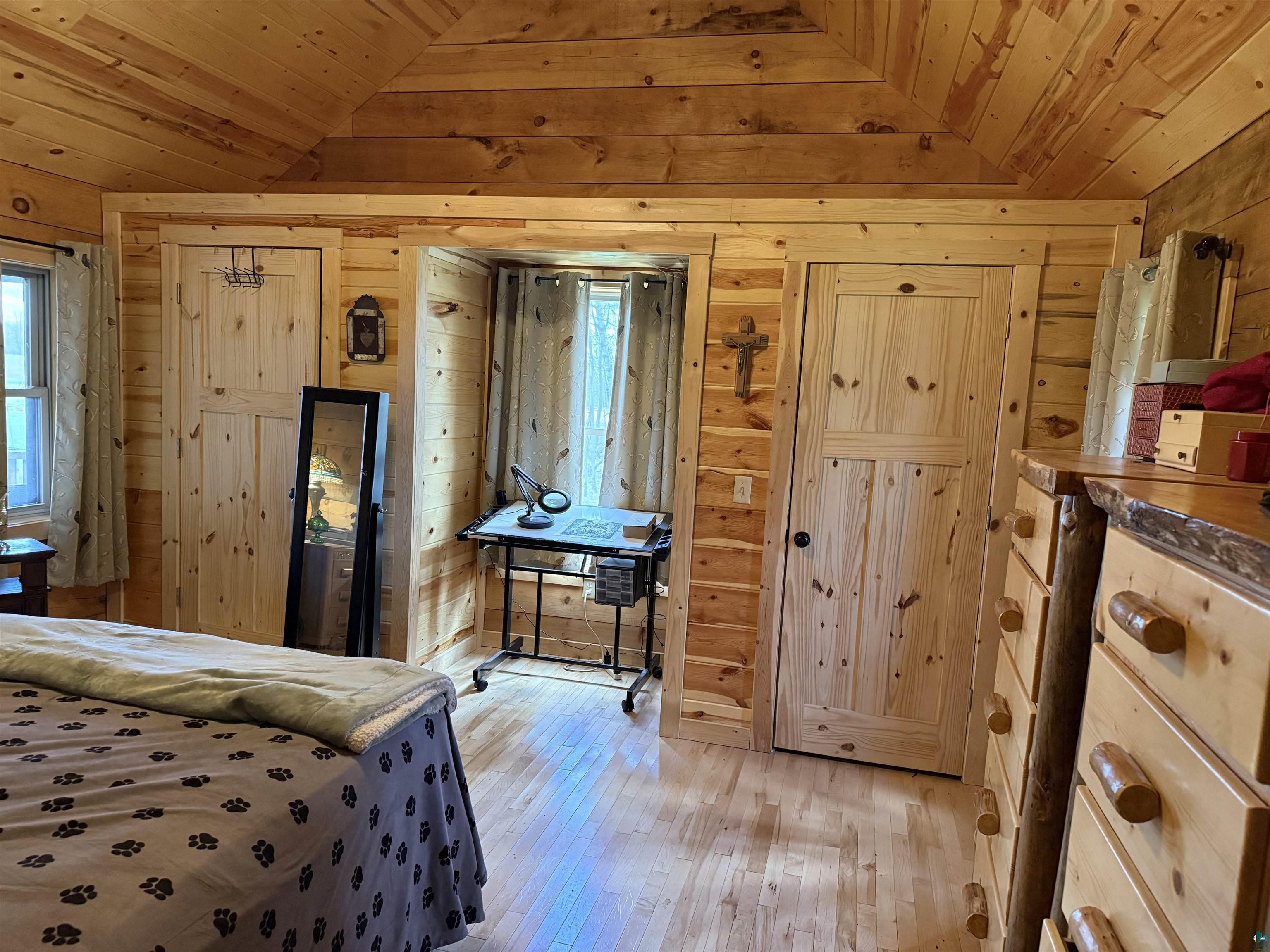 37590 Degerstrom Road Askov, MN 55704 - Photo 17 of 53 Wood-finish flooring with full wood-paneled walls and a vaulted wood-paneled ceiling