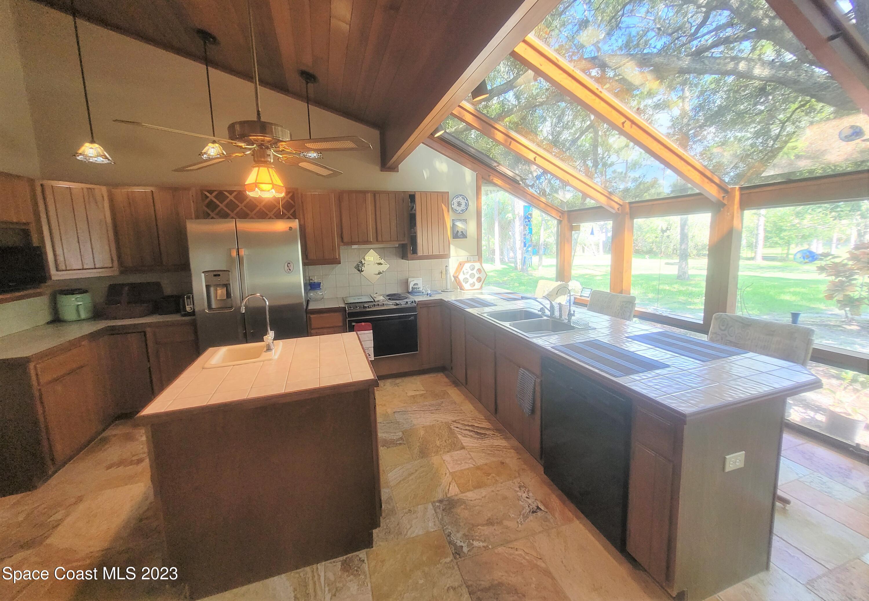 3805 Corey Road Malabar, FL 32950 - Photo 15 of 72 a large kitchen with kitchen island a sink a counter top space and stainless steel appliances