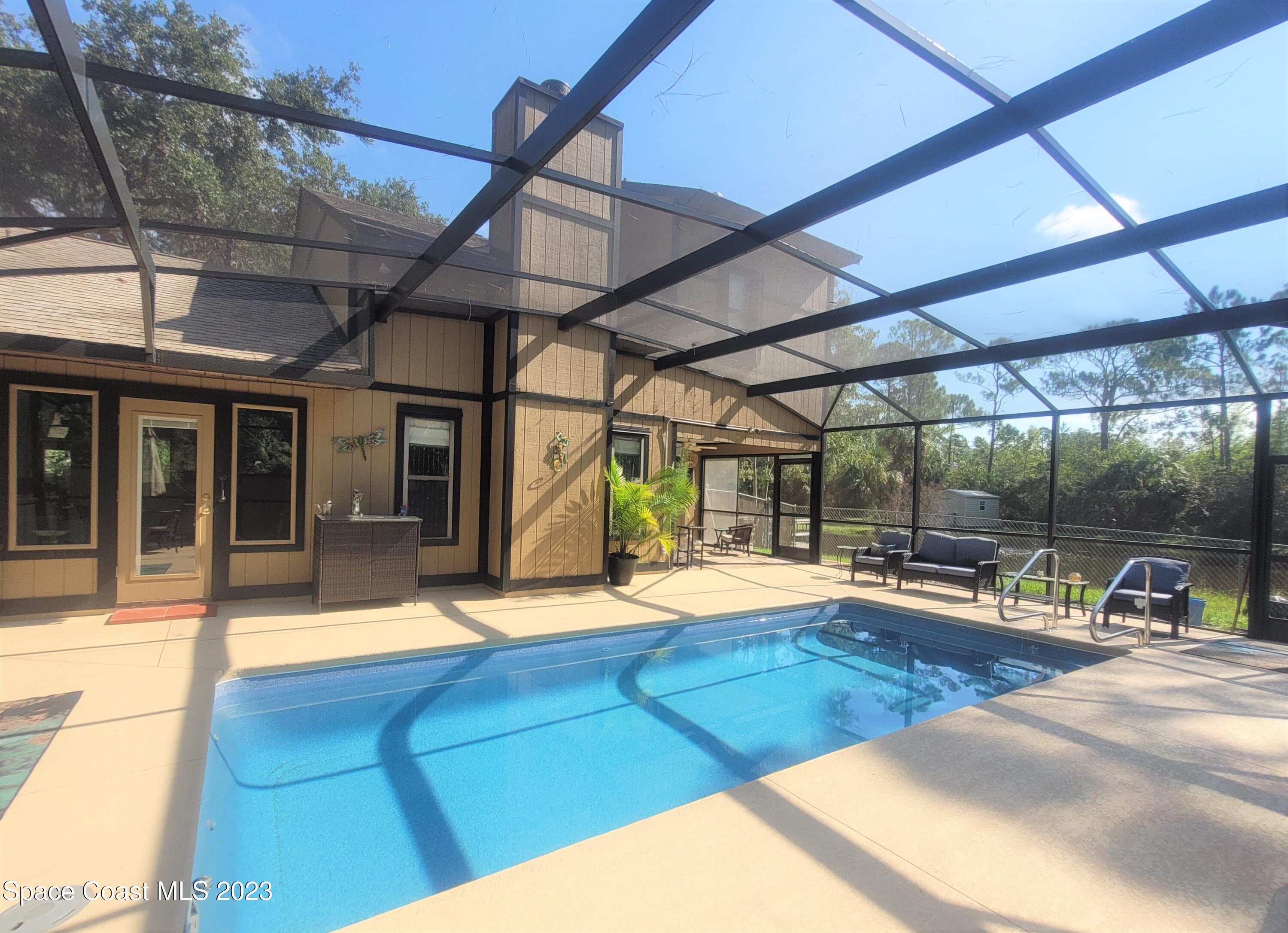 3805 Corey Road Malabar, FL 32950 - Photo 43 of 72 a view of a patio with a table and chairs under an umbrella