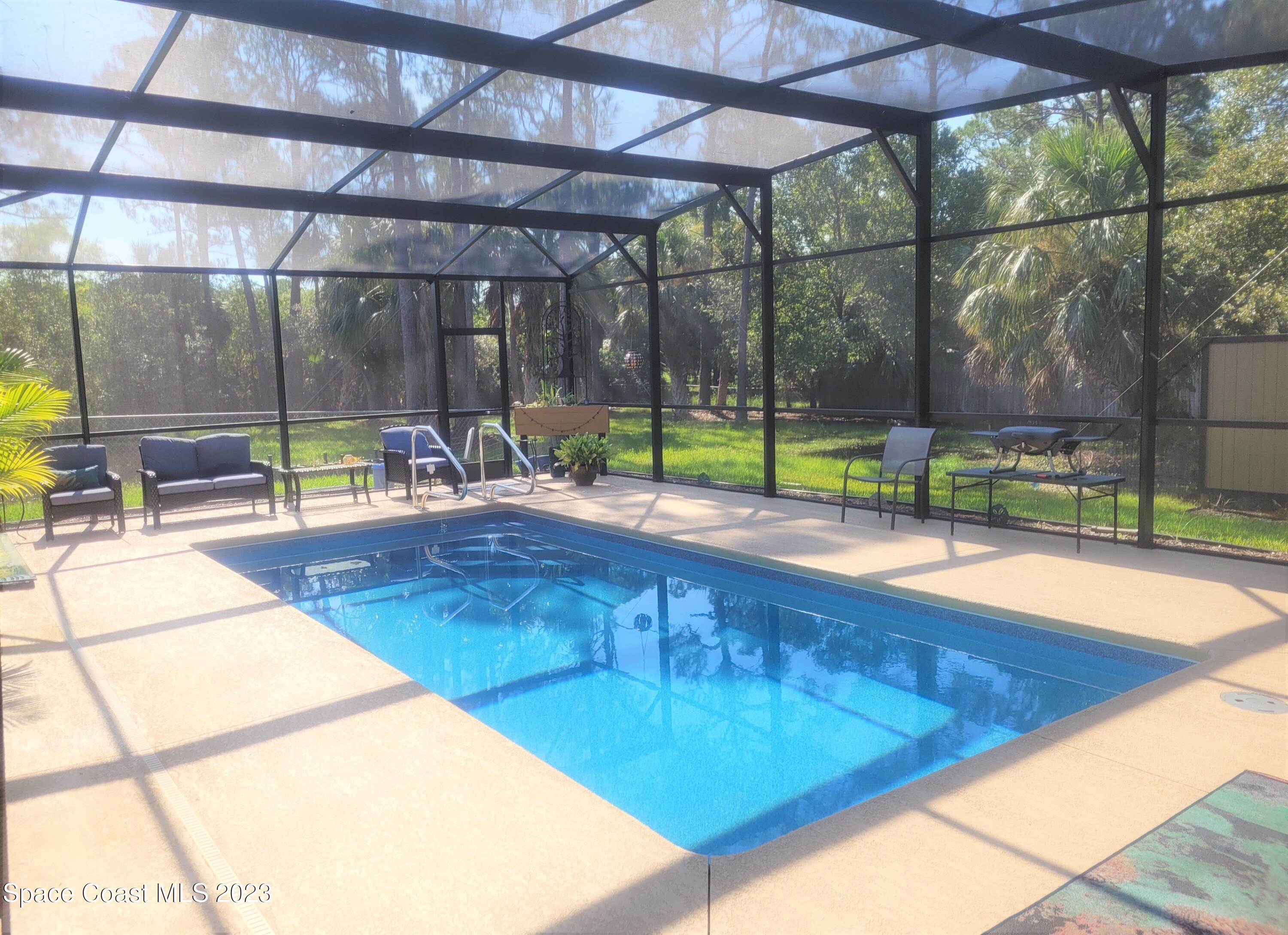 3805 Corey Road Malabar, FL 32950 - Photo 45 of 72 a swimming pool with outdoor seating and yard