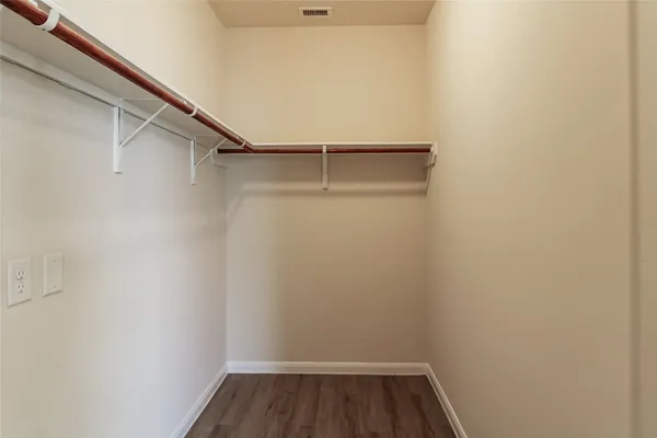 a view of walk in closet with empty racks