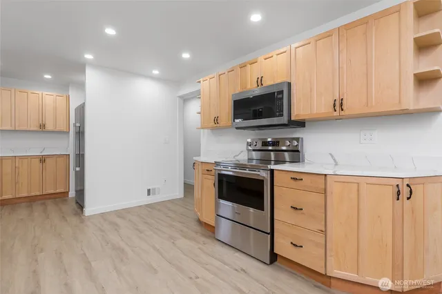 a kitchen with granite countertop white cabinets and stainless steel appliances