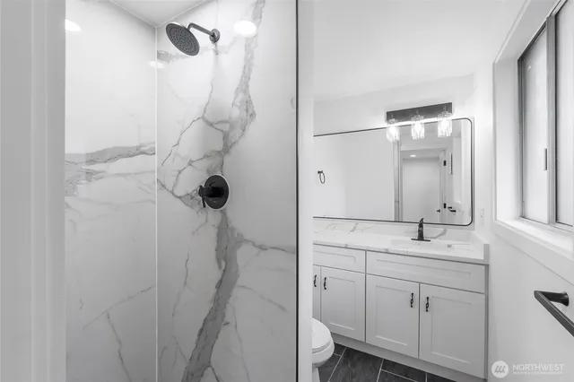 a bathroom with a sink a toilet and shower