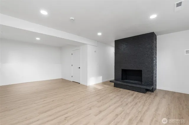 an empty room with wooden floor and fireplace