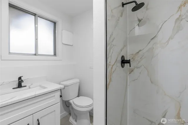 a bathroom with a sink a toilet and a shower