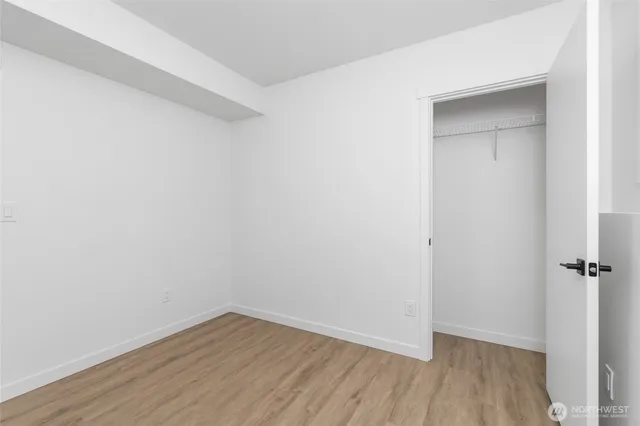 a view of a small space with wooden floor and a ceiling fan