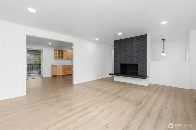 a view of empty room with wooden floor and fireplace