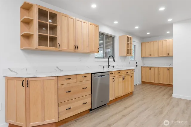 a kitchen with white cabinets and sink