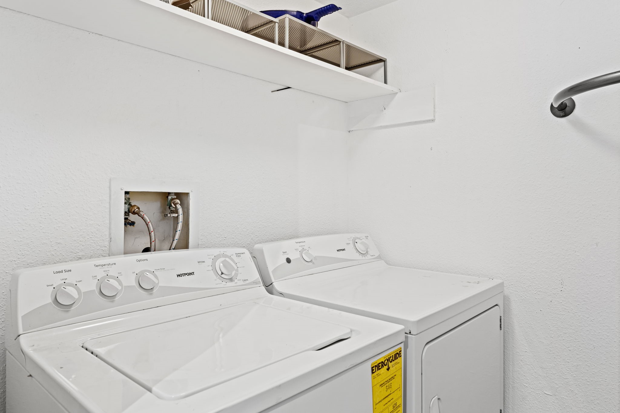 2211 South Kirkwood Road, Unit 1 Houston, TX 77077 - Photo 11 of 16 The dedicated first-floor utility room houses a full-size side-by-side washer and dryer — not stacked, not tucked behind a bifold door in the hallway. An overhead shelf adds storage above, and the setup is contained in its own room entirely separate from the living spaces.