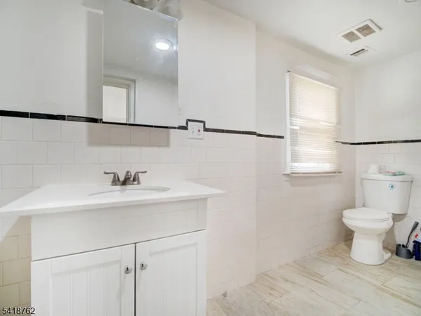 a bathroom with a sink a toilet and mirror