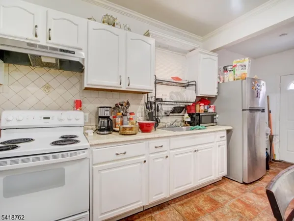a kitchen with stainless steel appliances white cabinets and white appliances