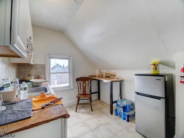 a living room with furniture and a refrigerator