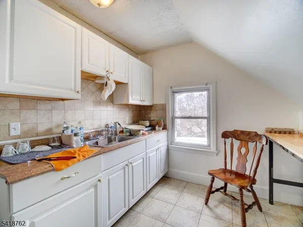 a kitchen with stainless steel appliances granite countertop a white cabinets and a stove top oven