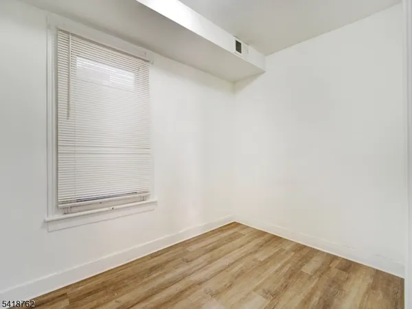 a view of a small space with wooden floor and a window