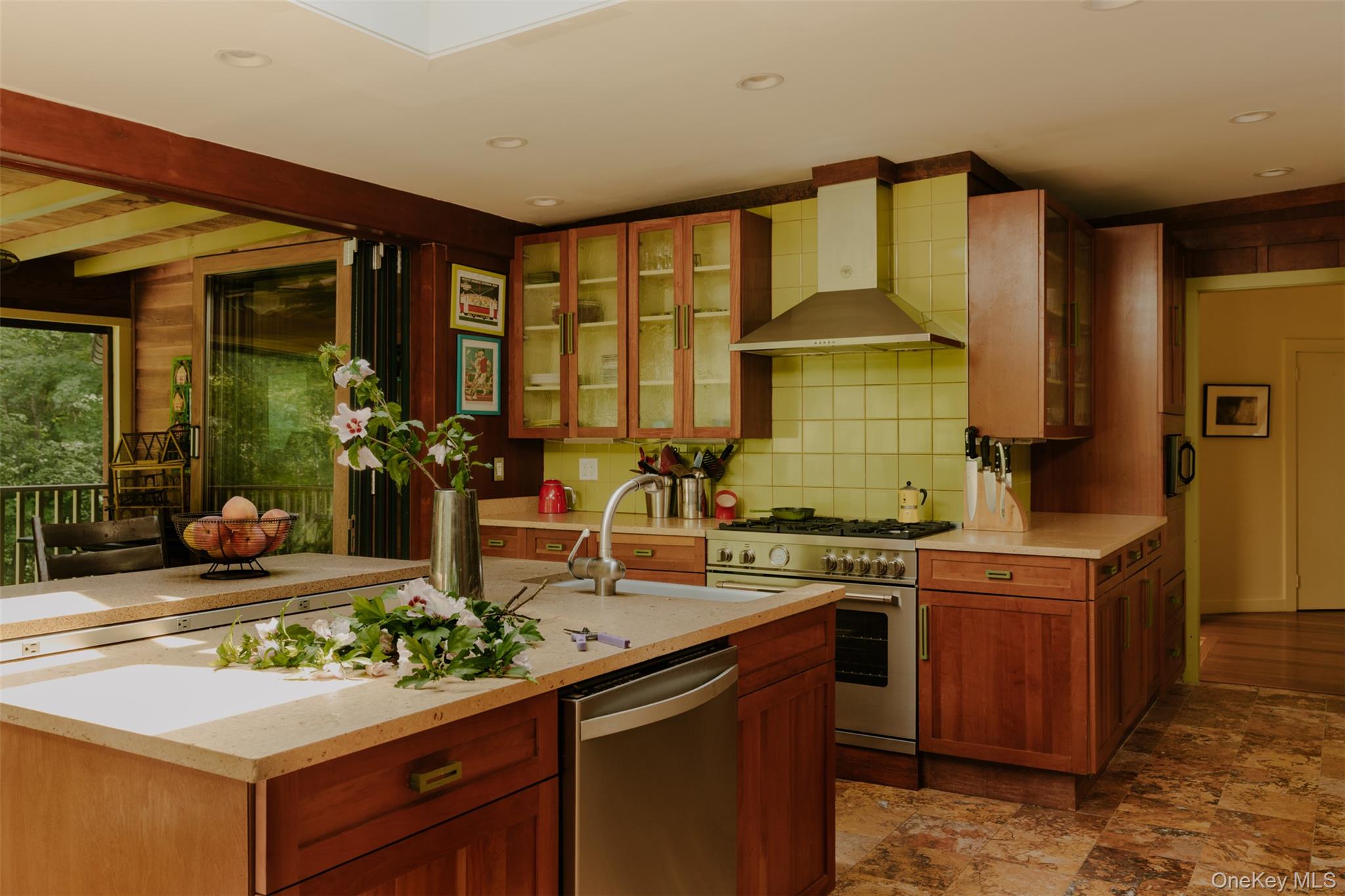481 Old Albany Post Road Garrison, NY 10524 - Photo 12 of 29 Large kitchen featuring an expansive central island with integrated dishwasher, light-toned countertops, rich wood cabinetry, and a stainless steel professional-grade range with a matching vent hood