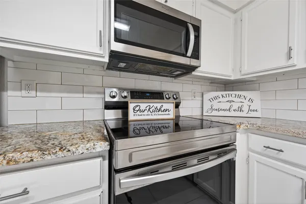 a kitchen with stainless steel appliances granite countertop a stove and a microwave
