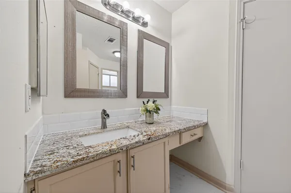 a bathroom with a granite countertop sink and a mirror