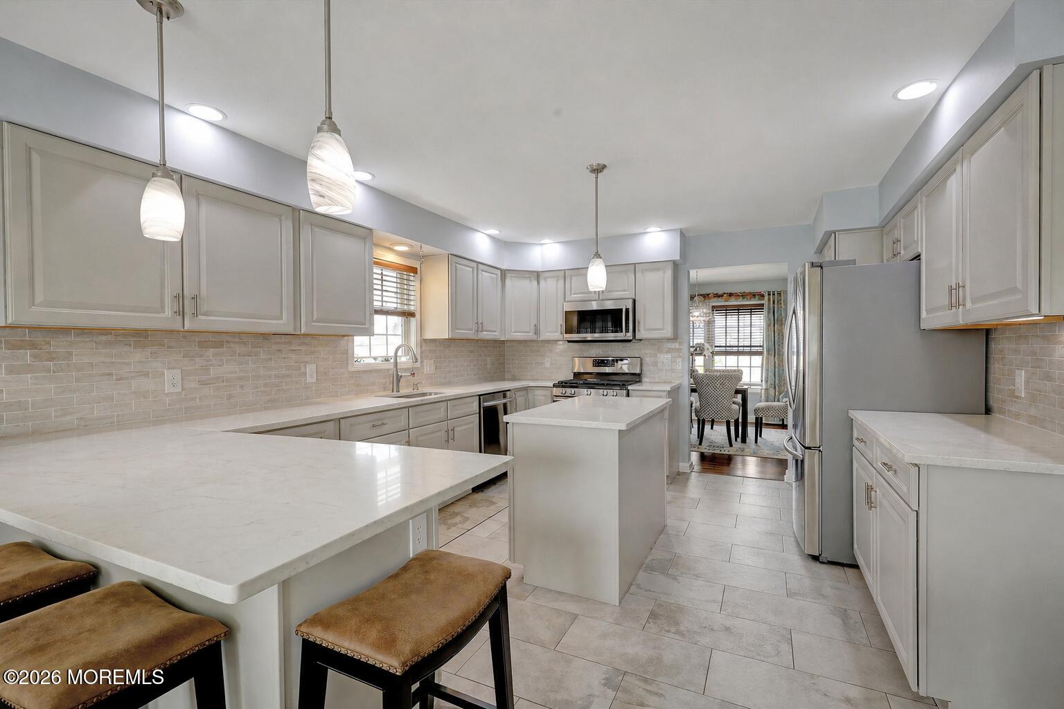 728 Drum Point Road Brick, NJ 08723 - Photo 2 of 6 a kitchen with a table chairs microwave and cabinets