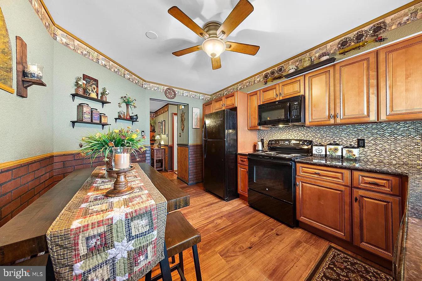 22 Fir Road Manahawkin, NJ 08050 - Photo 18 of 35 a kitchen with stainless steel appliances kitchen island granite countertop a refrigerator a stove a sink a dining table and chairs with wooden floor