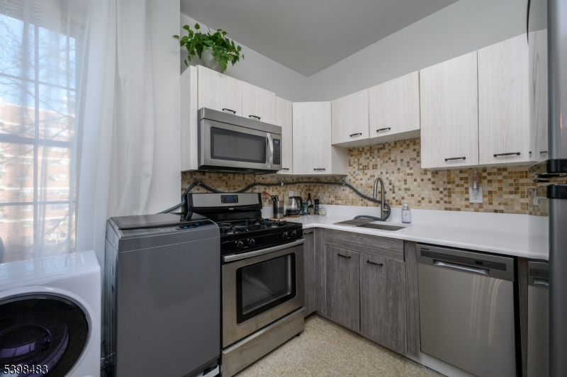 55 Randolph Place, Unit 301 South Orange, NJ 07079 - Photo 13 of 23 a kitchen with cabinets stainless steel appliances and a sink