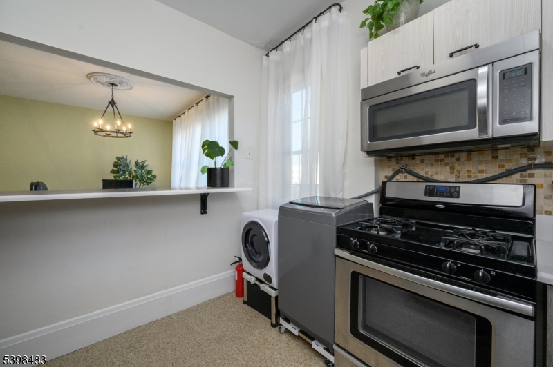 55 Randolph Place, Unit 301 South Orange, NJ 07079 - Photo 17 of 23 a kitchen with stainless steel appliances a stove a microwave and cabinets