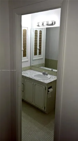 a bathroom with a granite countertop sink and mirror