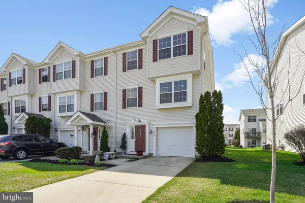 a front view of a house with a yard and trees