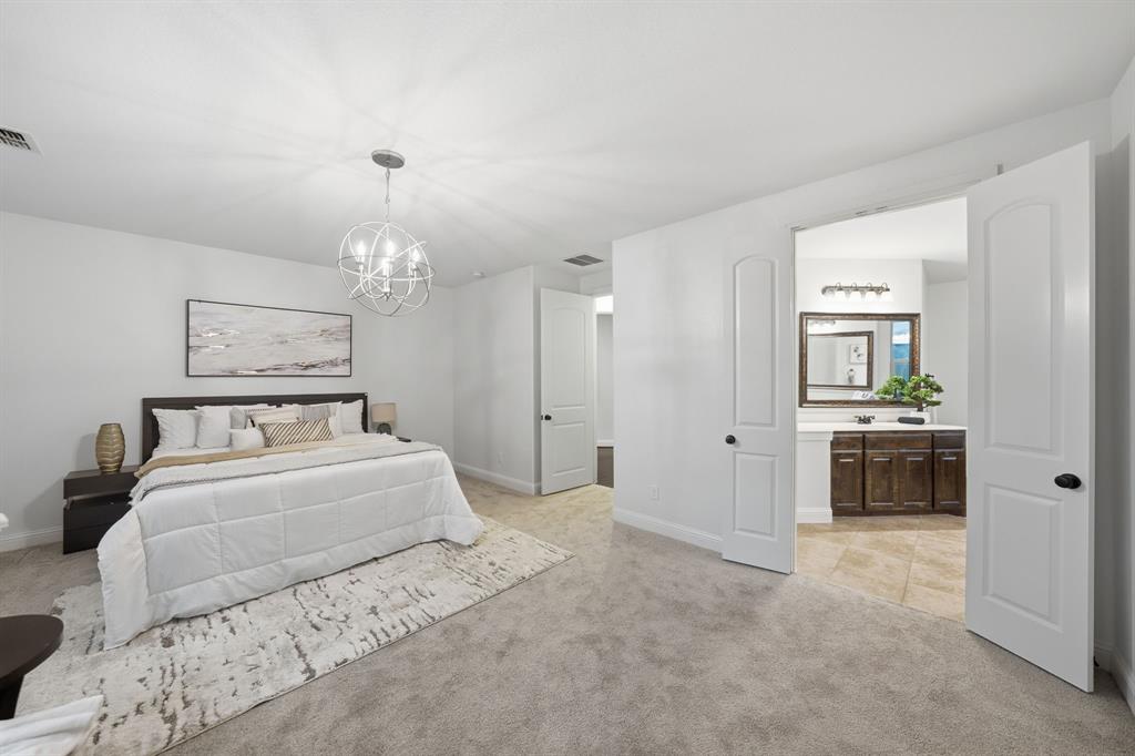 624 Sorrell Road McKinney, TX 75072 - Photo 11 of 28 a spacious bedroom with a bed a chandelier and a mirror