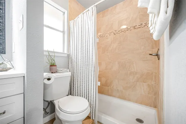 a bathroom with a toilet and a shower