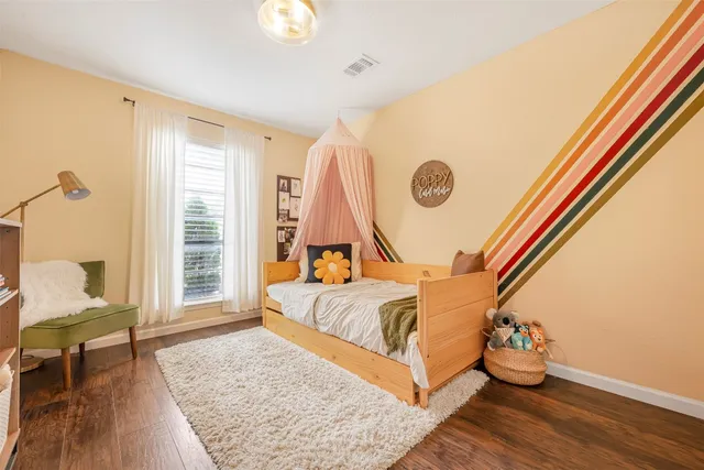 a bed sitting in a spacious bedroom next to a window