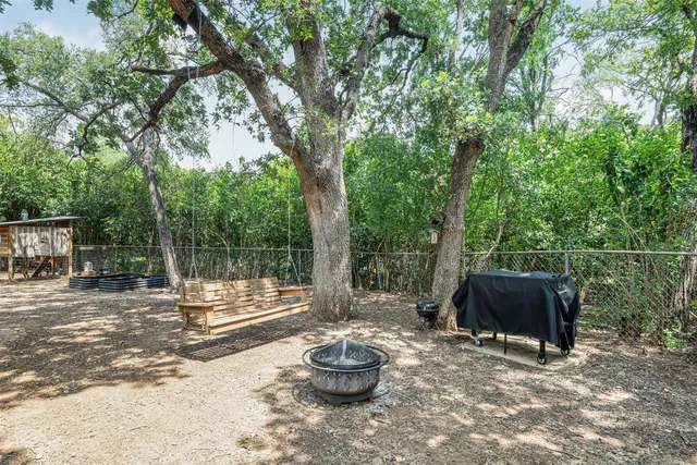 a backyard of a house with trampoline and fountain