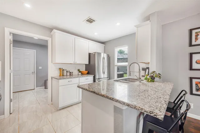 a kitchen with stainless steel appliances granite countertop a sink refrigerator and cabinets