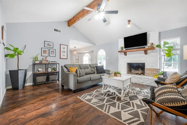 a living room with furniture a fireplace and a flat screen tv