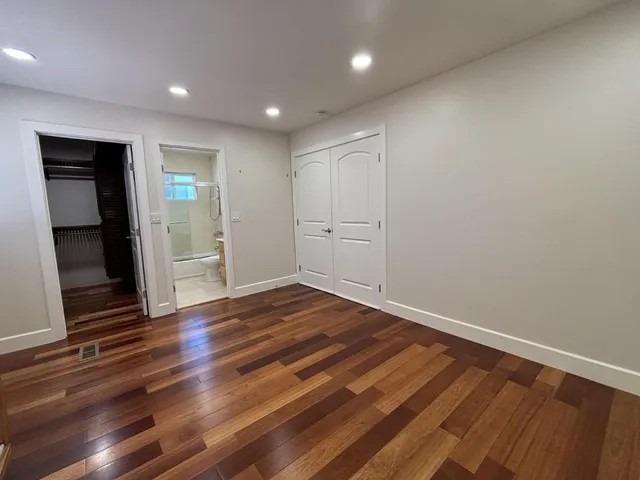 a view of empty room with wooden floor