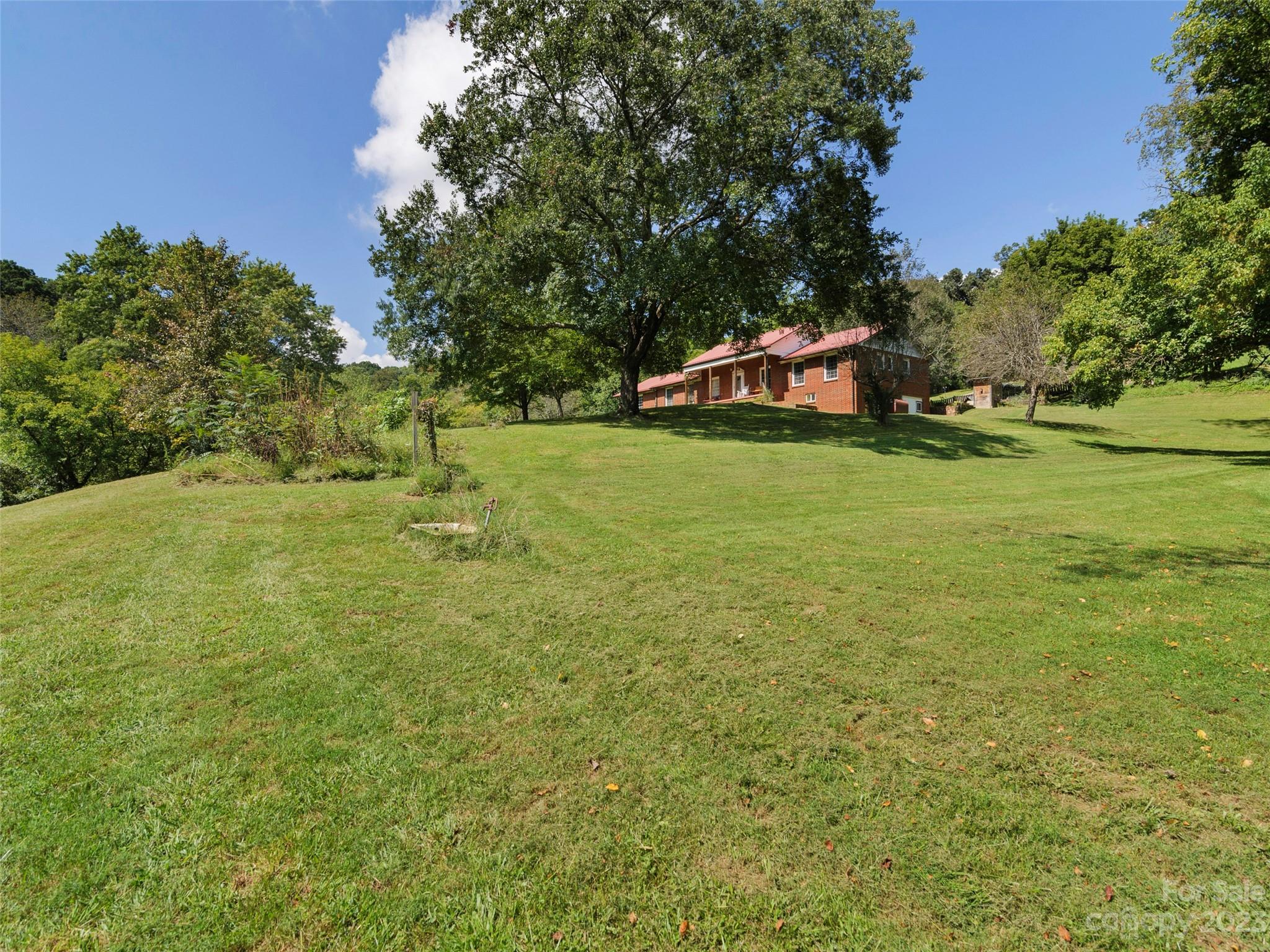 450 Chambers Road Waynesville, NC 28786 - Photo 27 of 28 a backyard of a house with lots of green space and fountain