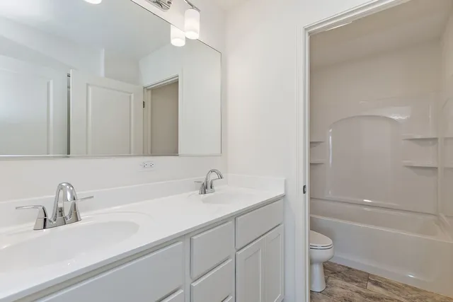 a bathroom with a sink a toilet and a large mirror